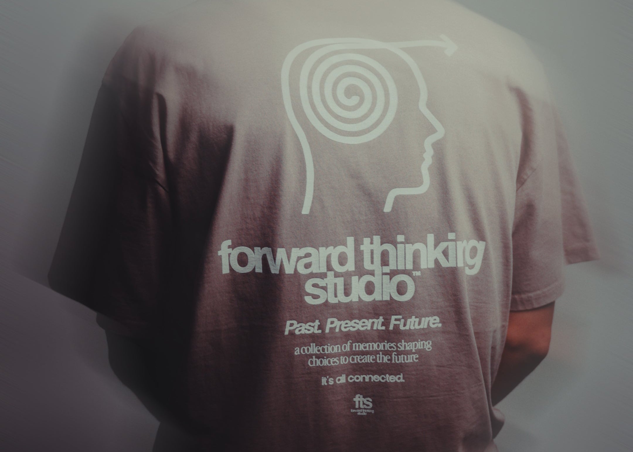 Person wearing a t-shirt with 'forward thinking studio' design on the back.